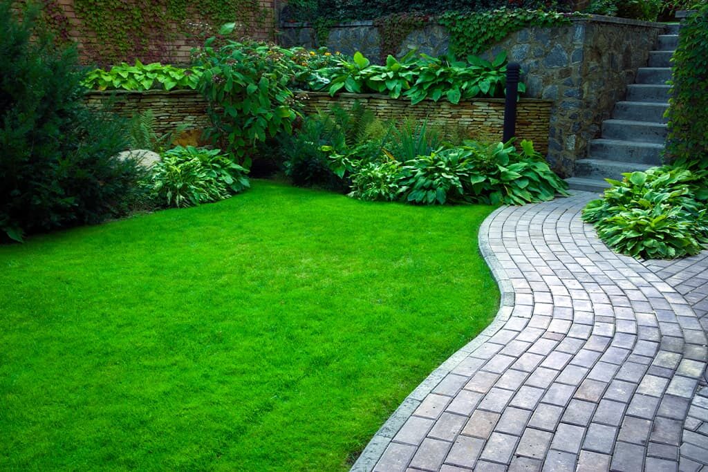Curved lawn and path with tiered stone walling in a finished garden