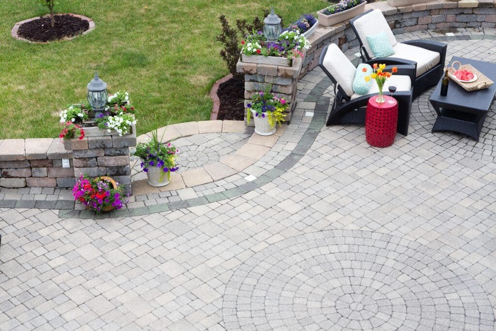 Circular stone patio with retaining wall and brick pillars, built by AM Landscaping & Paving